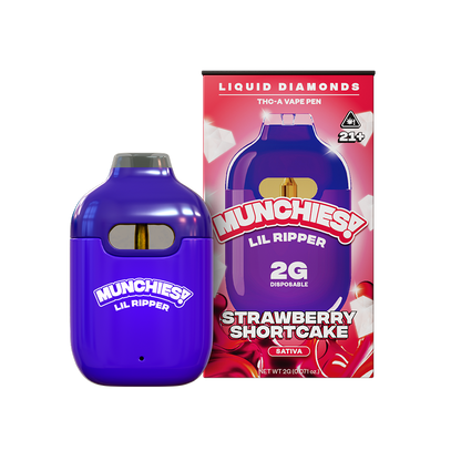 A purple disposable vape pen labeled "Delta Munchies: Munchies Lil Ripper THCA Disposable Vape | 2g" is placed next to its box, featuring a strawberry shortcake design and a 21+ age warning.